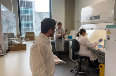 Image shows journalist watching the lab team at work