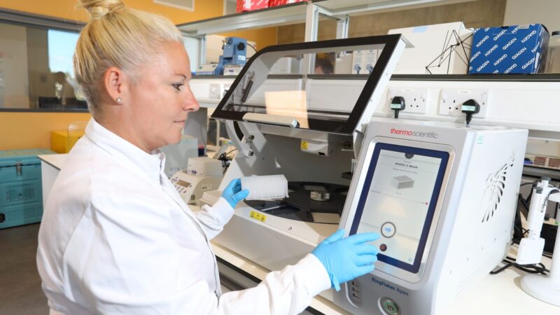 Scientist Dr Caroline Wilson operating a large piece of equipment in the innovation lab.