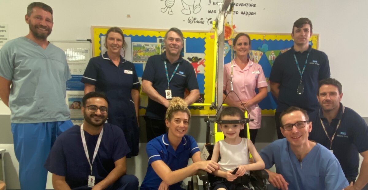 Kyle with the halo device surrounded by medical engineering, nursing and surgery teams.