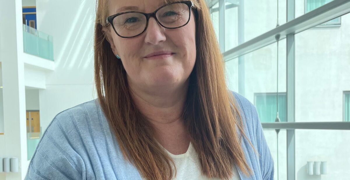 Michelle in the RVI wearing a white top and a blue cardigan.