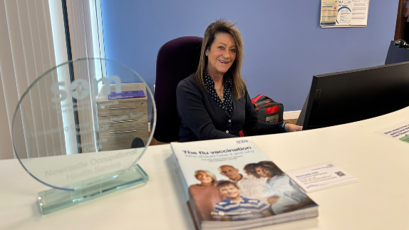 A receptionist sat behind a desk at the occupational health department.