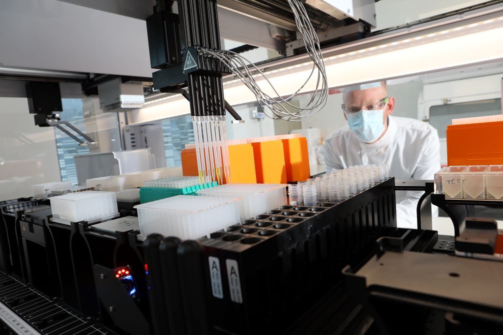 A scientist working on a piece of lab equipment.