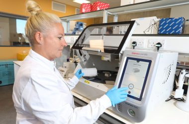 Image shows female scientist operating lab equipment