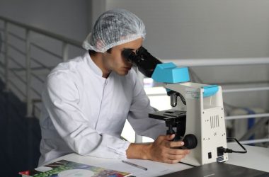 Image shows a scientist at a microscope
